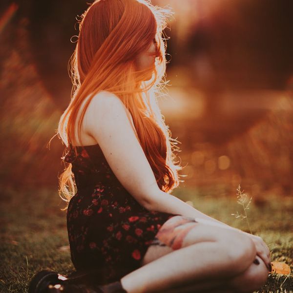 Woman meditating peacefully in a bright, serene environment.